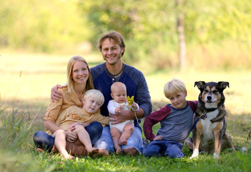 Symbolbild Familiäre Veränderungen - eine Familie mit Hund im Grünen